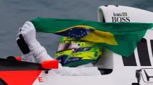 Lewis Hamilton, da Mercedes, agita a bandeira do Brasil enquanto dirige o McLaren MP4/5B do ex-campeão mundial Ayrton Senna, antes da corrida | Foto: Amanda Perobelli/Reuters
