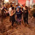 Pessoas limpam ruas com lama em Valência