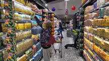 black friday 2024 - uma senhora no corredor de um mercado busca um item na prateleira de cima