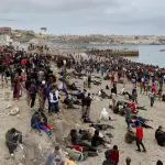 Centenas de imigrantes marroquinos invadem praia na Espanha: descontrole e excesso de regulamentações travaram a economia europeia, diz analista | Foto: reprodução/Twitter/X