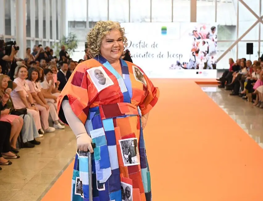 Senhora anda na passarela do desfile do Instituto do Câncer de São Paulo