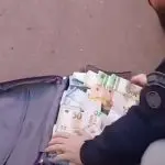 Agente da PRF recolhe dinheiro furtado de agência no Espírito Santos: valor equivalente a R$ 1,5 milhão em notas de reais, dólar e euro | Foto: Divulgação/Polícia Rodoviária Federal