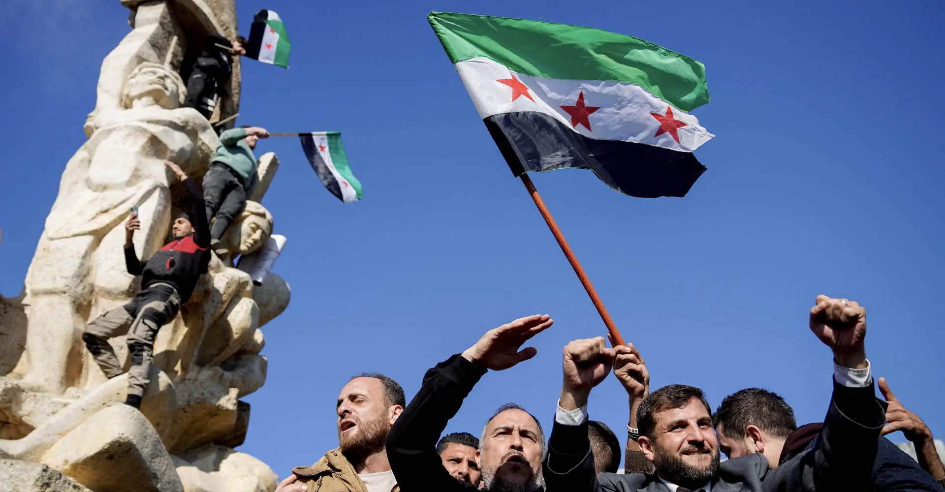 Pessoas agitam bandeira adotada pelos novos governantes da Síria