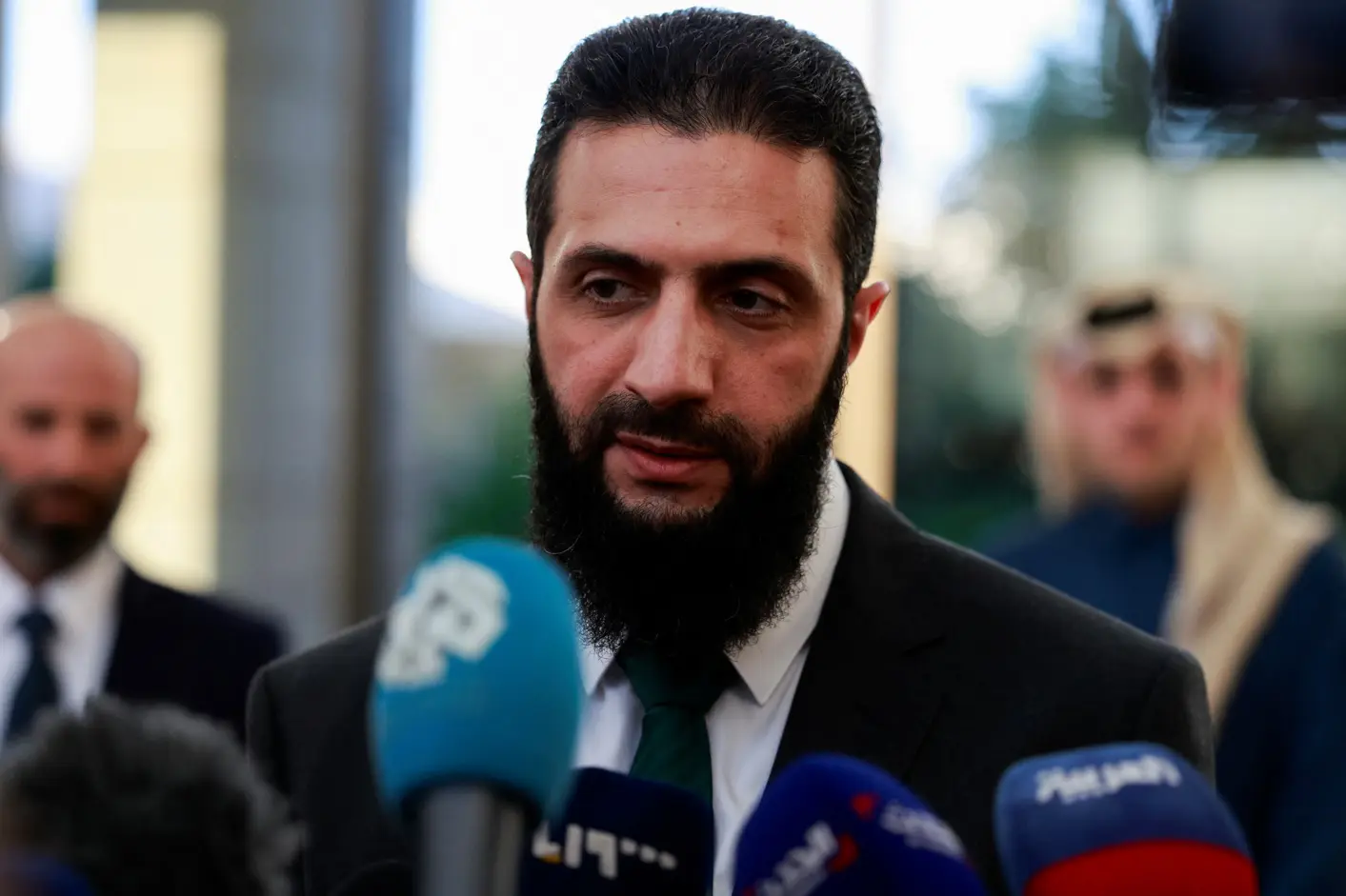 Ahmed al-Sharaa, em conversa com a imprensa, durante uma reunião com o ministro de Estado do Catar, Mohammed bin Abdulaziz Al-Khulaifi, depois da deposição de Bashar al-Assad da Síria, em Damasco - 23/12/2024 | Foto: Ammar Awad/Reuters