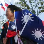 Uma mulher segura bandeiras, em meio às comemorações do 130º aniversário de fundação do maior partido de oposição de Taiwan, o Kuomintang (KMT), em Taoyuan, Taiwan - 24/11/2024 | Foto: Ann Wang/Reuters