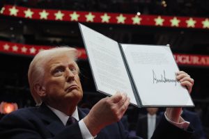 Donald Trump, presidente dos EUA, apresenta uma ordem executiva durante o desfile inaugural dentro da Capital One Arena no dia da posse de seu segundo mandato presidencial, em Washington, EUA (20/1/2025) | Foto: Reuters/Carlos Barria