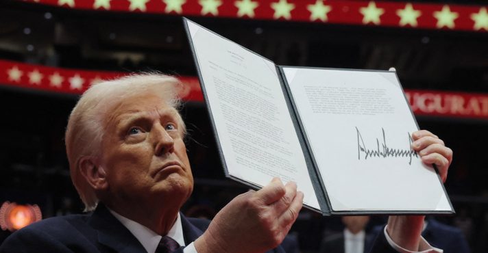 Donald Trump, presidente dos EUA, apresenta uma ordem executiva durante o desfile inaugural dentro da Capital One Arena no dia da posse de seu segundo mandato presidencial, em Washington, EUA (20/1/2025) | Foto: Reuters/Carlos Barria