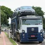 Carros 0km em caminhão cegonha, em alusão à nota sobre imposto em veículos novos no Brasil