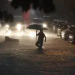 Pedestre atravessa ponto de alagamento no cruzamento das Ruas Aspicuelta com Simpatia, na Vila Madalena, na zona oeste de São Paulo, em decorrência de forte chuva