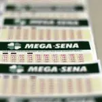 Exemplos de cartelas de jogo da Mega-Sena sobre uma mesa