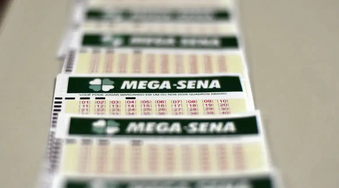 Exemplos de cartelas de jogo da Mega-Sena sobre uma mesa