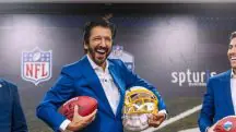 O prefeito de São Paulo, Ricardo Nunes, segurando a bola da NFL e um capacete de futebol americano. O prefeito sorri, durante coletiva de imprensa sobre o retorno da NFL ao Brasil