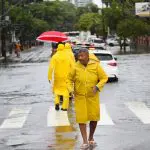 Pedestres se protegem da chuva e de alagamentos - 05/02/2025. Foto faz alusão à nota do aviso da Defesa Civil do Estado de São Paulo