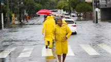 Pedestres se protegem da chuva e de alagamentos - 05/02/2025. Foto faz alusão à nota do aviso da Defesa Civil do Estado de São Paulo