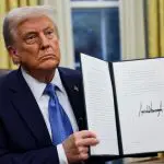 O presidente dos EUA, Donald Trump, segura uma ordem executiva no Salão Oval da Casa Branca, em Washington - 31/1/2025 | Foto: Carlos Barria/Reuters
