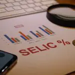 Taxa Selic - Gráfico representando evolução, lupa, teclado e calculadora. país