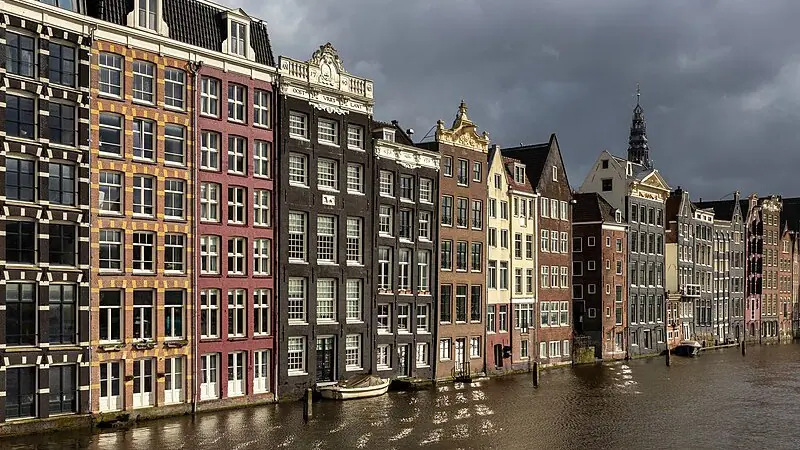 Casas coloridas do canal na hora dourada na avenida Damrak, Amsterdã, Holanda | Foto: Reprodução/Wikimedia Commons