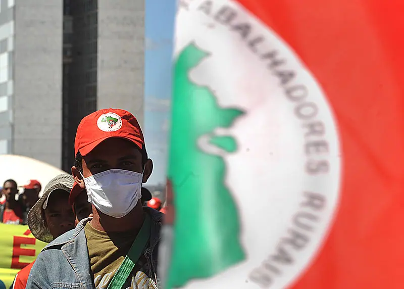 Integrante do Movimento dos Trabalhadores Rurais Sem Terra (MST) usa máscara durante manifestação na Esplanada dos Ministérios, em frente ao Congresso Nacional - 14/8/2009 | Foto: Marcello Casal Jr/Agência Brasil