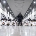 Policiais de El Salvador perto de membros da gangue venezuelana Tren de Aragua, recentemente deportados pelo governo dos EUA - 16/3/2025 | Foto: Secretaria de Prensa de la Presidencia/Reuters