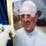 Uma pessoa observa uma imagem do papa Francisco, colocada do lado de fora da Capela da Virgem de Caacupe, depois da morte do pontífice, em Buenos Aires - 24/4/2025 | Matias Baglietto/Reuters