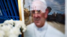 Uma pessoa observa uma imagem do papa Francisco, colocada do lado de fora da Capela da Virgem de Caacupe, depois da morte do pontífice, em Buenos Aires - 24/4/2025 | Matias Baglietto/Reuters