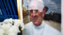 Uma pessoa observa uma imagem do papa Francisco, colocada do lado de fora da Capela da Virgem de Caacupe, depois da morte do pontífice, em Buenos Aires - 24/4/2025 | Matias Baglietto/Reuters