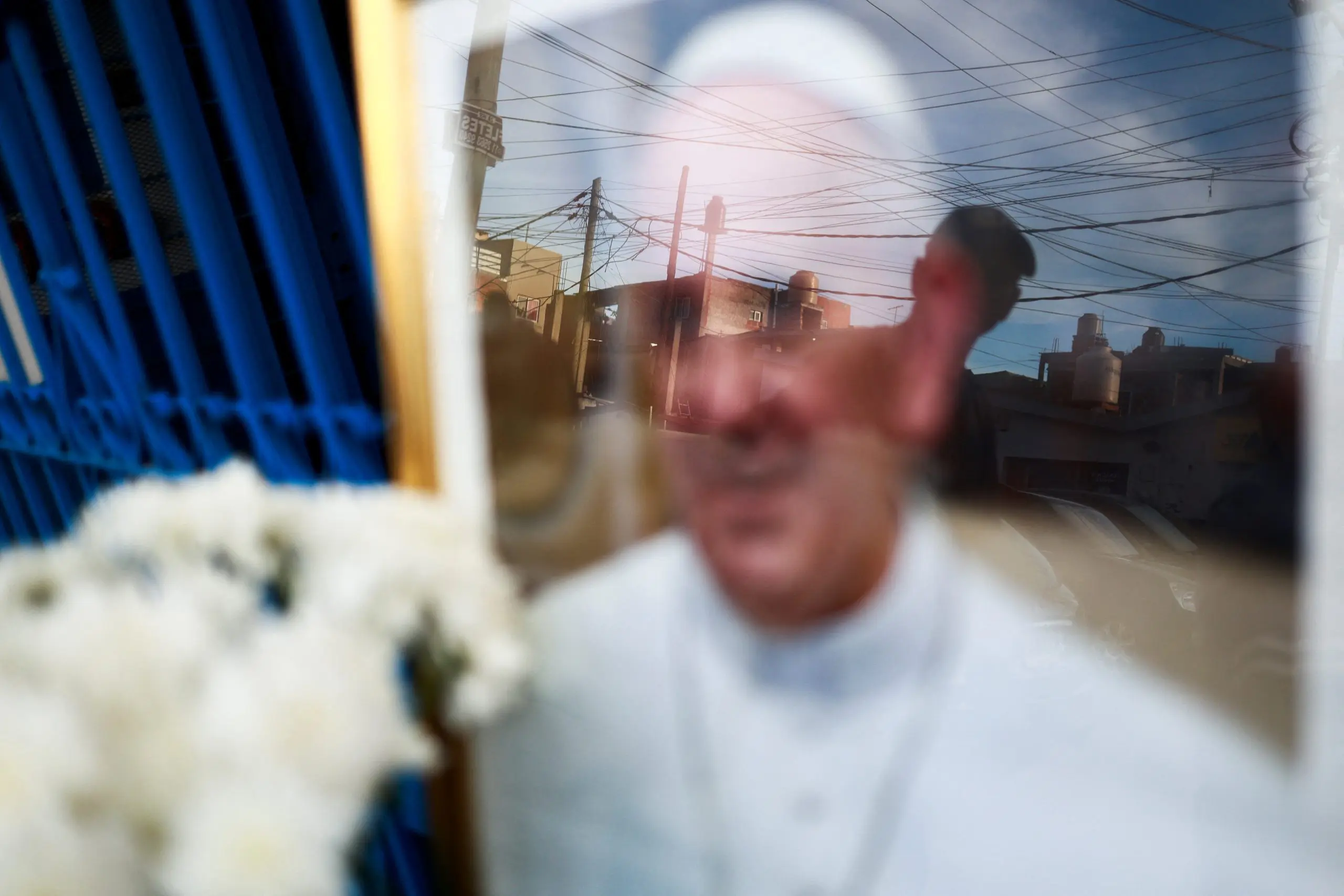 Uma pessoa observa uma imagem do papa Francisco, colocada do lado de fora da Capela da Virgem de Caacupe, depois da morte do pontífice, em Buenos Aires - 24/4/2025 | Matias Baglietto/Reuters