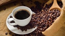 Grãos de café, ao lado da bebida pronta
