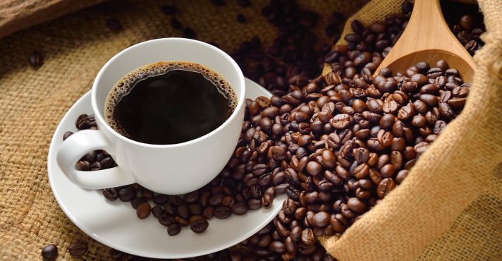 Grãos de café, ao lado da bebida pronta
