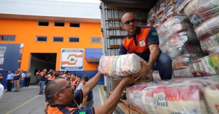 Agentes da Defesa Civil distribuem cestas básicas em cidade atingida pelo alto nível das águas no Amazonas | Foto: Divulgação/DCAM
