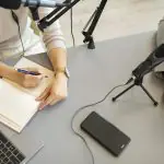 Itens tradicionais do trabalho de um jornalista, como microfone, papel, caneta e computador