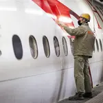 Funcionário aplica a película, inspirada na pele de tubarão, na fuselagem de um avião da companhia Austrian Airlines | Foto: Reprodução/Twitter/X