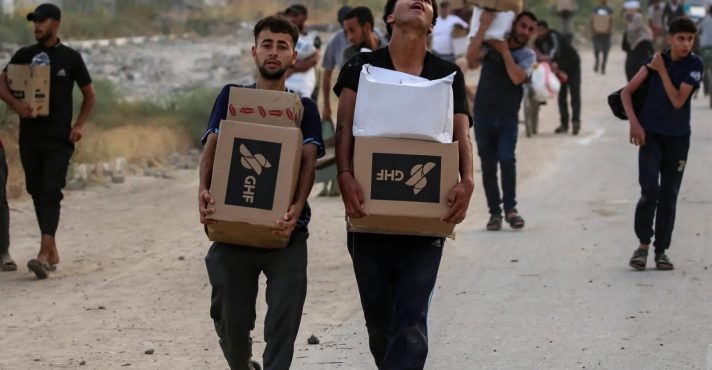 Palestinos transportam mantimentos entregues por funcionários da Fundação Humanitária de Gaza | Foto: Reprodução/Twitter/X