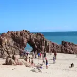A imagem mostra uma formação rochosa em arco na praia de Jericoacoara | Foto: Helio Bastos Salmon/Wikimedia Commons