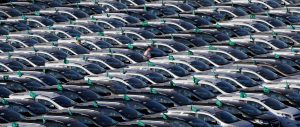Um trabalhador caminha por carros novos estacionados em fileiras no estacionamento da General Motors, GM, em São Bernardo do Campo, SP (2015) | Foto: Shutterstock