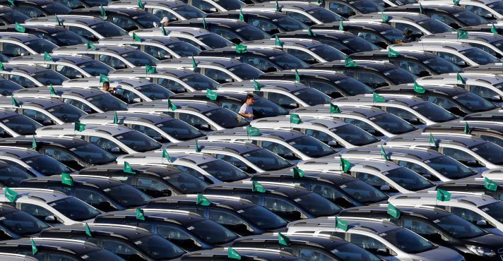 Um trabalhador caminha por carros novos estacionados em fileiras no estacionamento da General Motors, GM, em São Bernardo do Campo, SP (2015) | Foto: Shutterstock