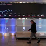 Um homem passa ao lado de um quadro eletrônico exibindo informações sobre as flutuações recentes dos índices de mercado na Bolsa de Valores B3, em São Paulo, Brasil (10/7/2025) | Foto: Reuters/Alexandre Meneghini