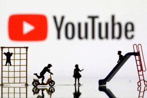 Miniaturas de parquinhos infantis são vistas em frente ao logotipo do YouTube, em ilustração feita em 4 de abril de 2023 | Foto: Dado Ruvic/Reuters