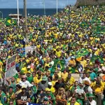 Os manifestantes, vestidos majoritariamente com as cores verde e amarela, marcham pela orla da Barra em direção ao Morro do Cristo, na Bahia | Foto: Reprodução/X