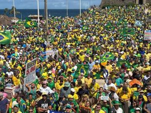 Os manifestantes, vestidos majoritariamente com as cores verde e amarela, marcham pela orla da Barra em direção ao Morro do Cristo, na Bahia | Foto: Reprodução/X