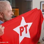 Presidente Luiz Inácio Lula da Silva segurando a bandeira do PT