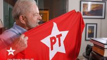 Presidente Luiz Inácio Lula da Silva segurando a bandeira do PT