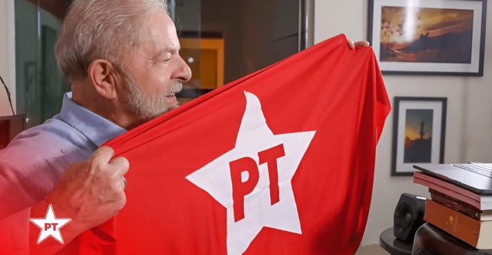 Presidente Luiz Inácio Lula da Silva segurando a bandeira do PT