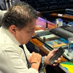 Acorrentado a sua mesa no Senado, Magno Malta observa o celular: cresce a pressão pelo impeachment de Alexandre de Moraes | Foto: Reprodução/Redes sociais