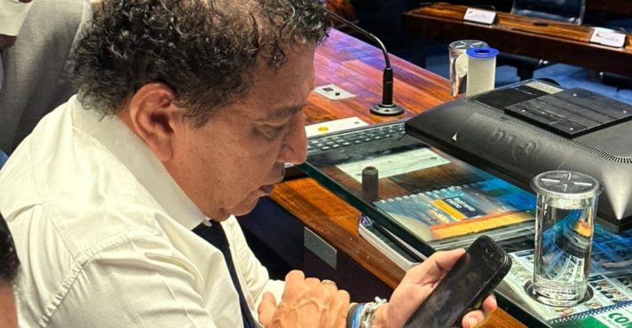 Acorrentado a sua mesa no Senado, Magno Malta observa o celular: cresce a pressão pelo impeachment de Alexandre de Moraes | Foto: Reprodução/Redes sociais