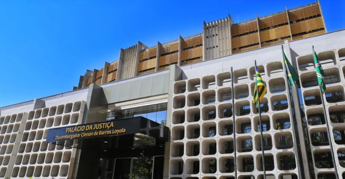Fachada Tribunal de Justiça de Goiás; juíza ri em audiência de custódia