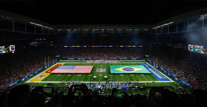 Bandeiras dos Estados Unidos e Brasil estendidas no gramado da Neo Química Arena, em São Paulo, durante o segundo jogo da NFL no Brasil | Foto: Reprodução/NFL