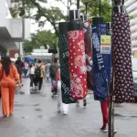Comerciante oferece guarda-chuvas em rua de São Paulo | Foto: Rovena Rosa/Agência Brasi