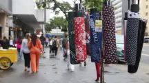 Comerciante oferece guarda-chuvas em rua de São Paulo | Foto: Rovena Rosa/Agência Brasi