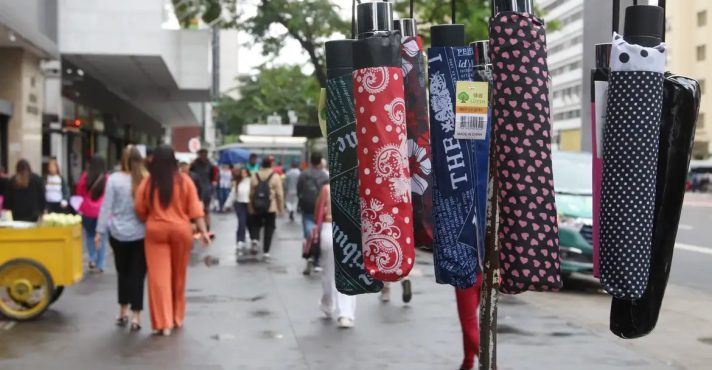 Comerciante oferece guarda-chuvas em rua de São Paulo | Foto: Rovena Rosa/Agência Brasi
